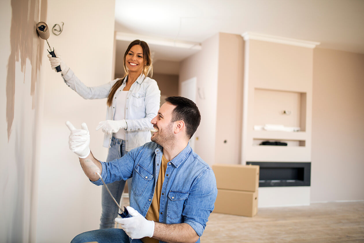 mann und frau beim streichen der wand