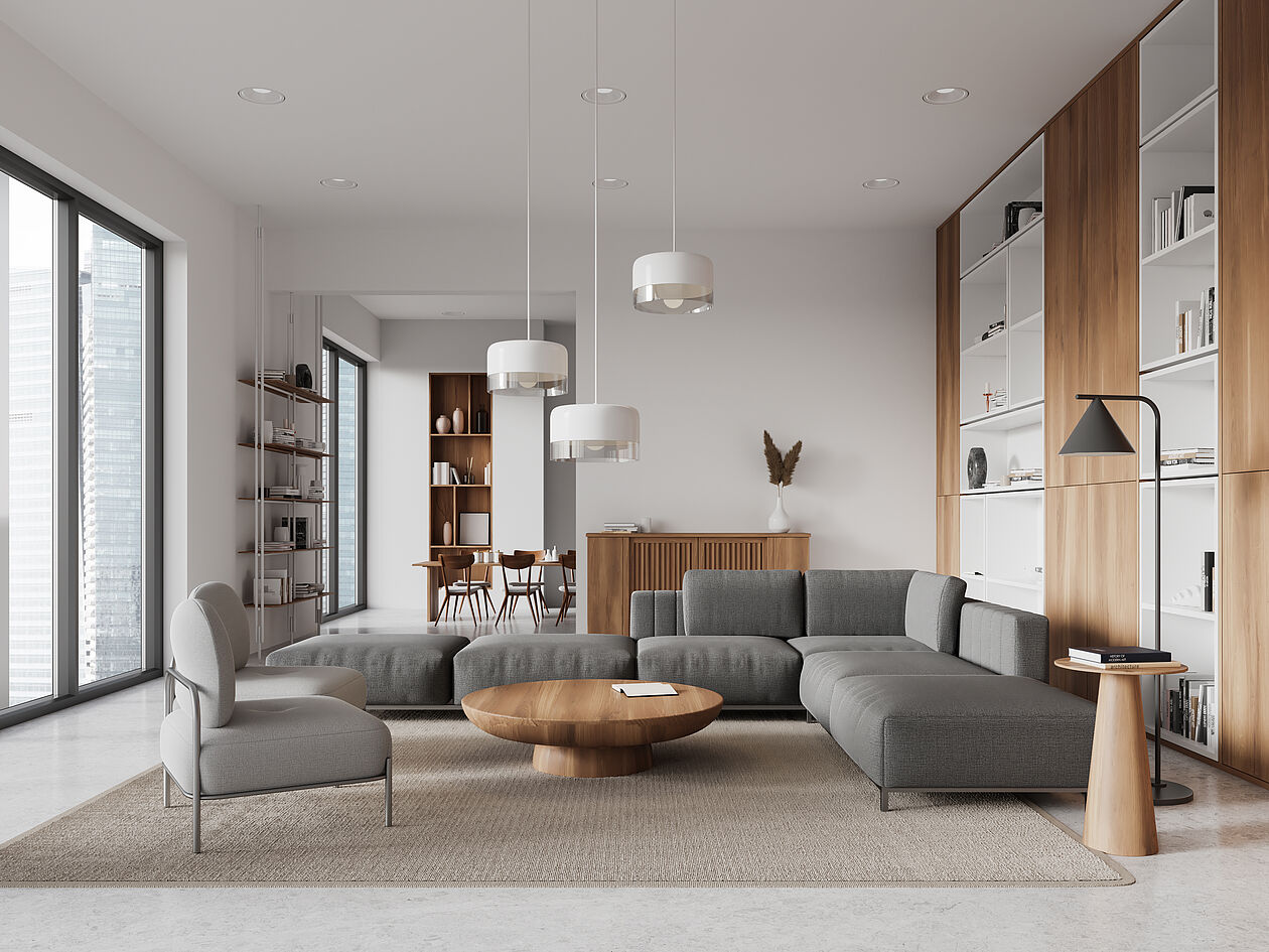 Ein modern eingerichtetes Wohnzimmer mit Sofa, Sesseln, Esstisch und Einbauregalen.
