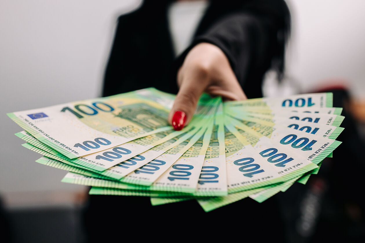 Frau hält Geldscheine