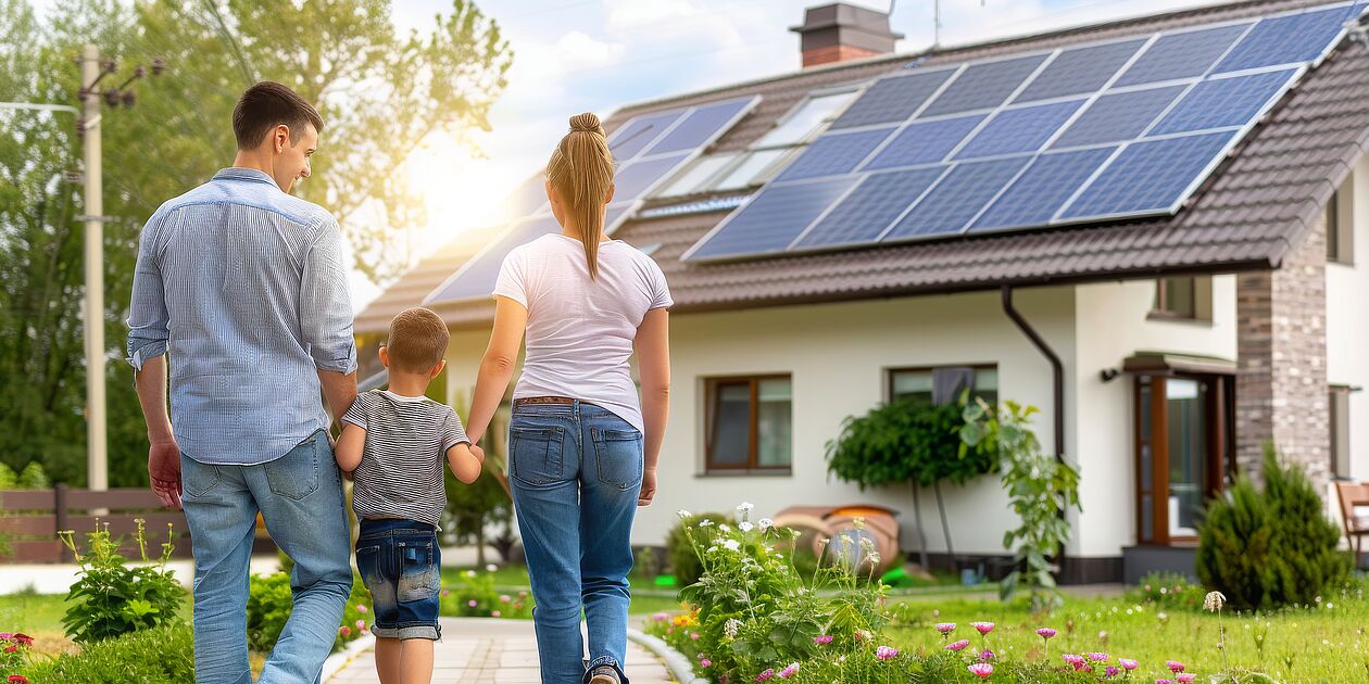 Familie vor Haus mit Photovoltaik
