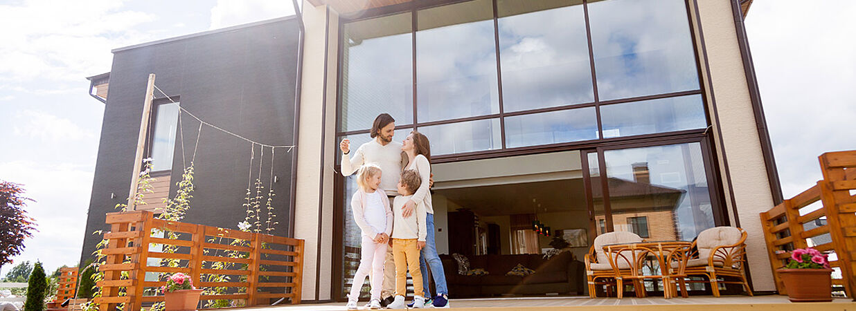 glückliche Familie vor neuem Haus