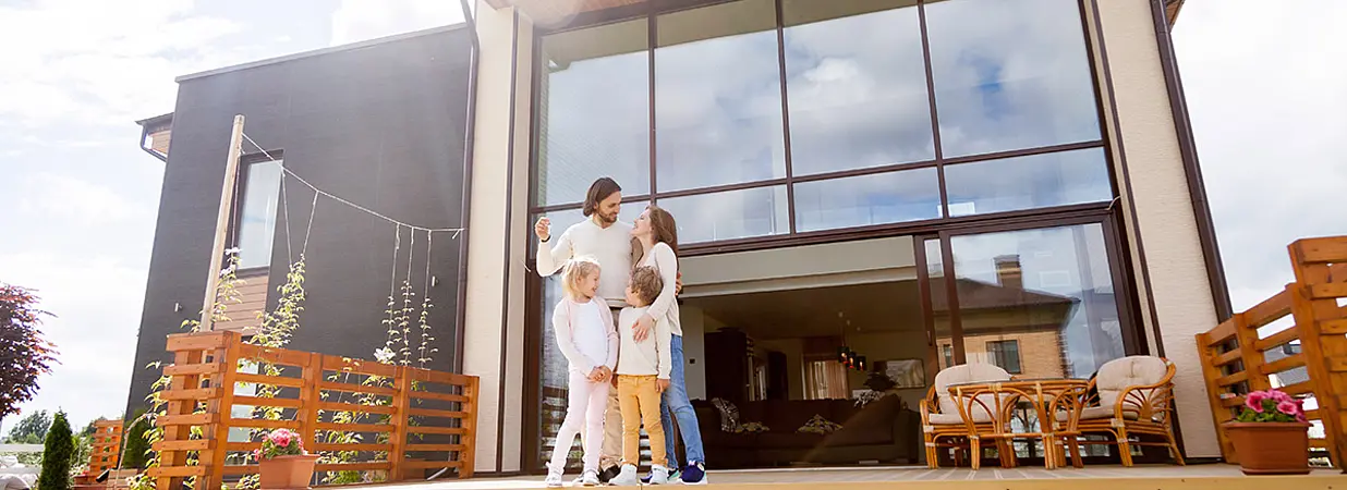 glückliche Familie vor neuem Haus