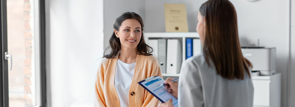 Arzt untersucht lächelnden Patienten mit Stethoskop, Symbol für Gesundheitskredit und Behandlung.