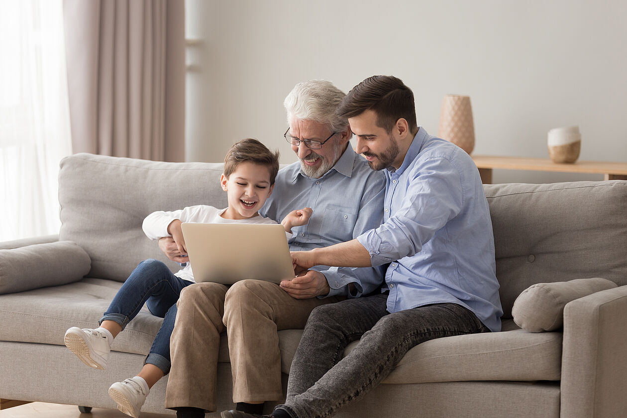 mann schaut mit sohn und enkel in pc