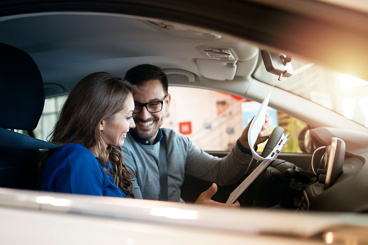 zwei lachende personen im auto