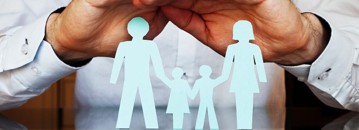 Familie aus Papier, darüber Hände