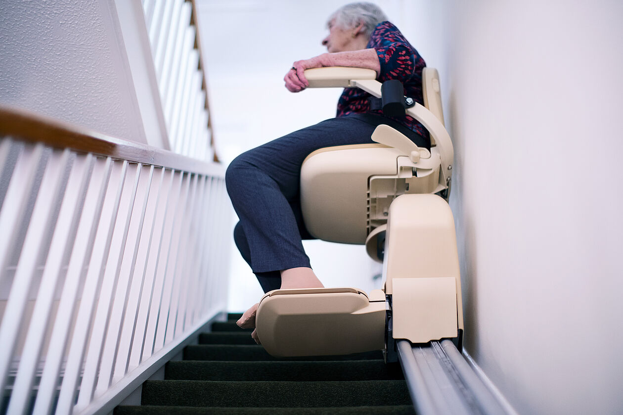 ältere Frau auf Treppenlift