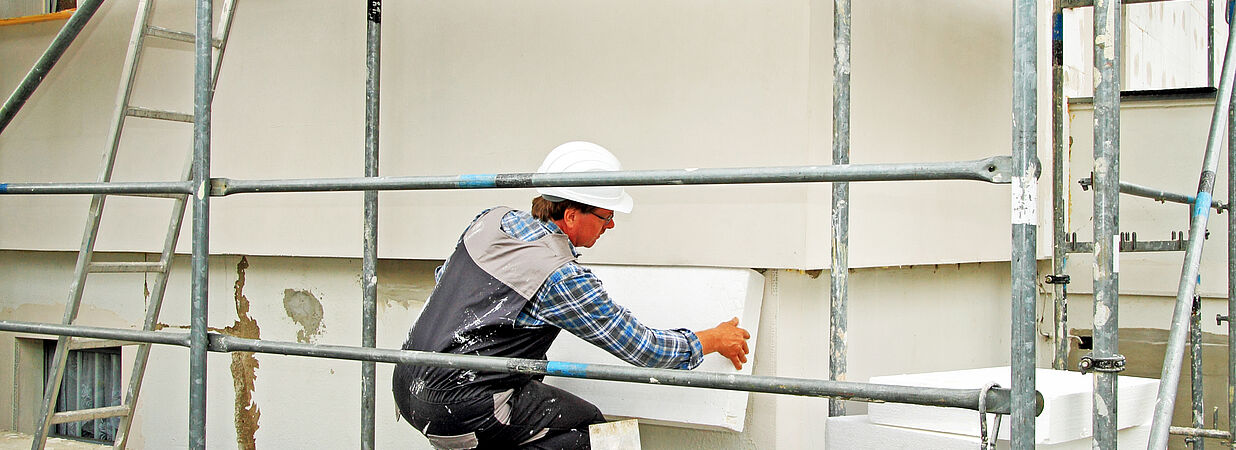 Arbeiter erneuert Fassade