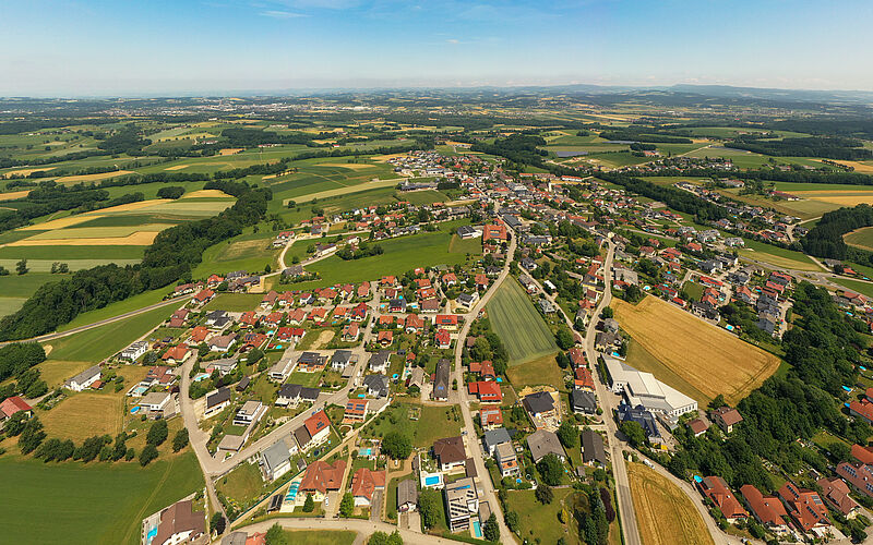 Luftaufnahme von Häusern, Grundstücken und Feldern in einer ländlichen Siedlung in Österreich.