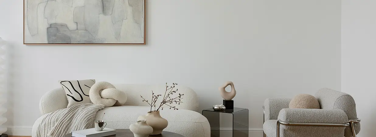 Modern eingerichtetes Wohnzimmer mit Designermöbeln, heller Atmosphäre und dezenten Dekorationen.