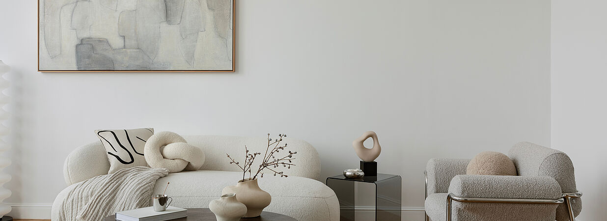 Modern eingerichtetes Wohnzimmer mit Designermöbeln, heller Atmosphäre und dezenten Dekorationen.