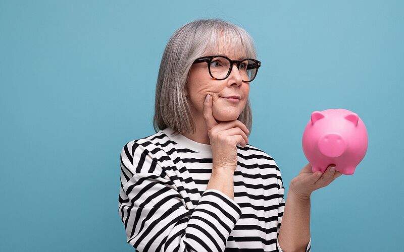 nachdenkliche Frau mit Sparschwein