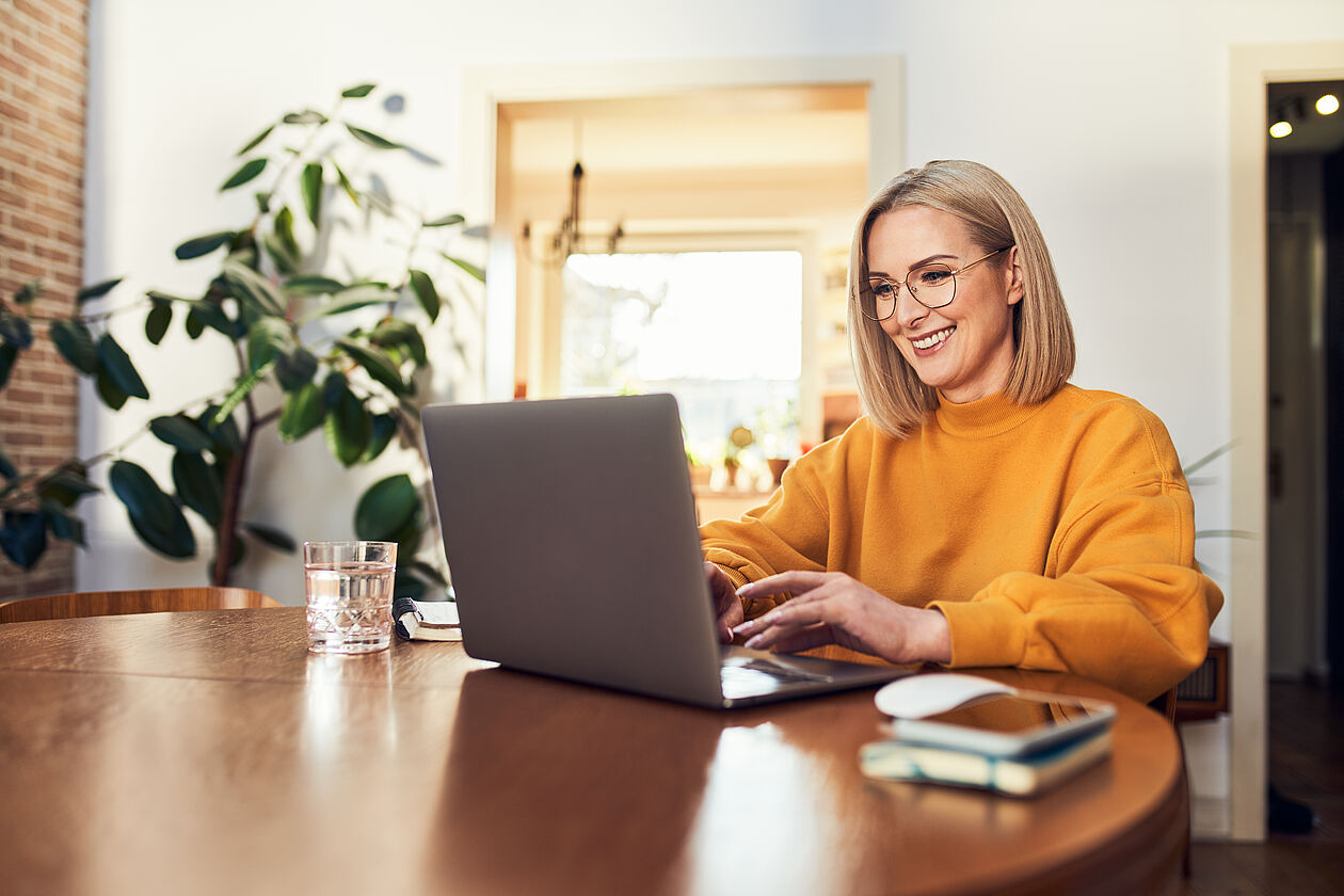 Frau in ihrer Wohnung am Laptop