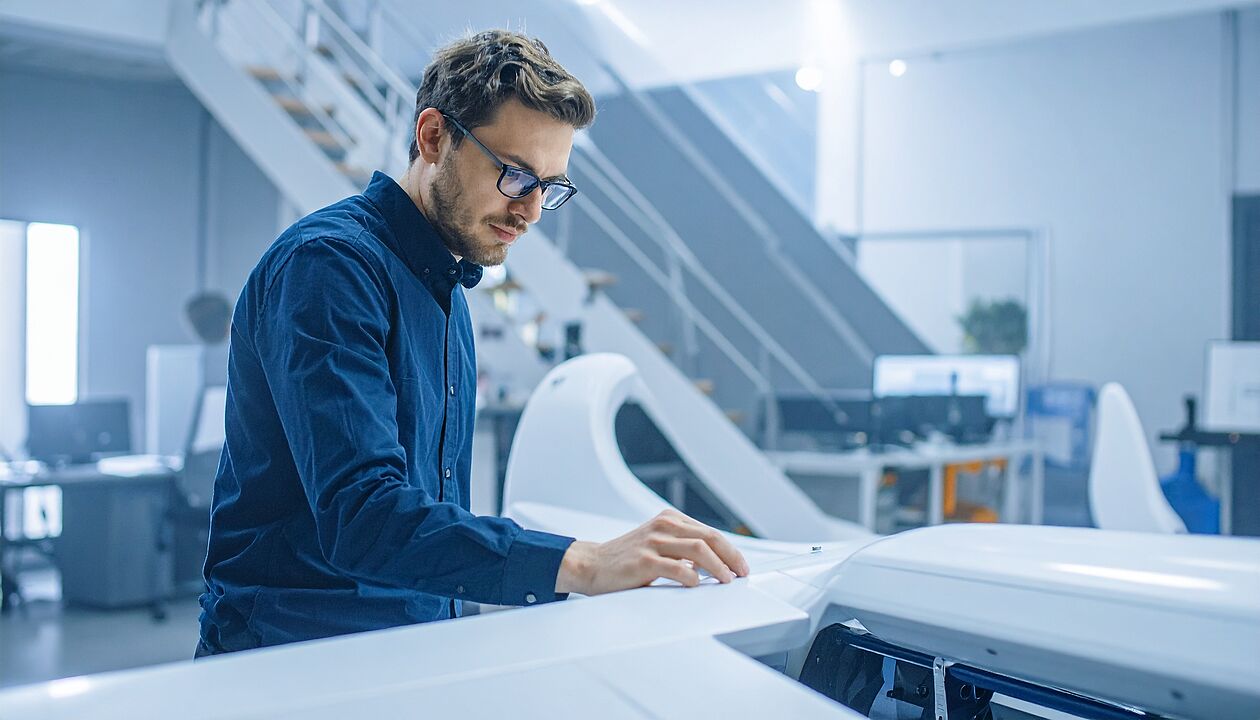 Ingenieur arbeitet an technischer Innovation in moderner Produktionsumgebung.