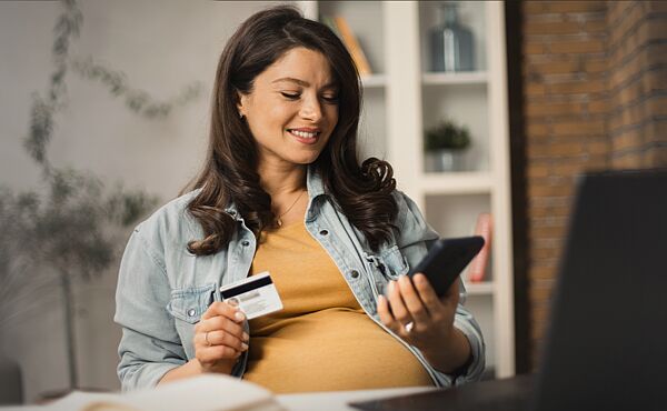 schwangerer frau hält kreditkarte