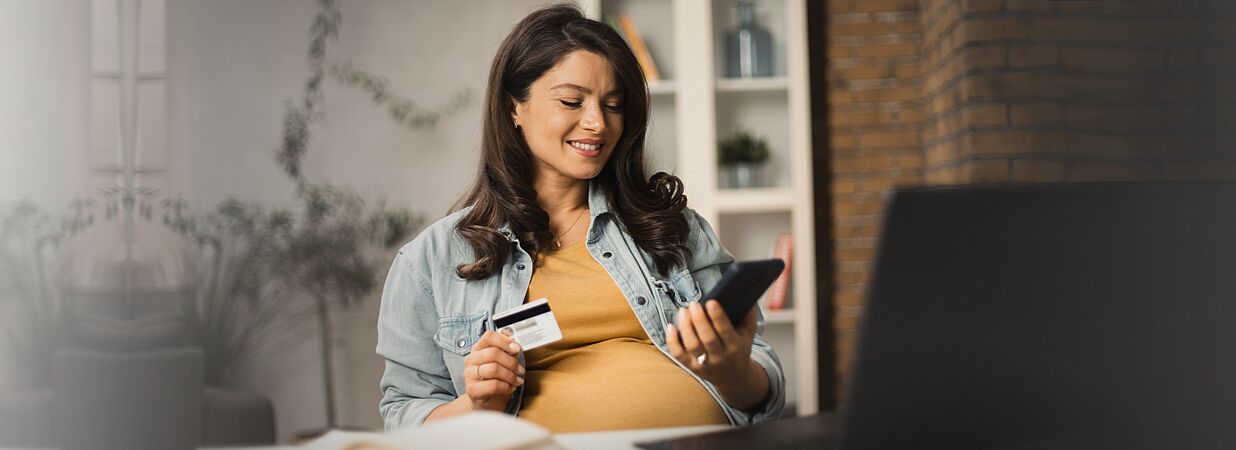 schwangerer frau hält kreditkarte