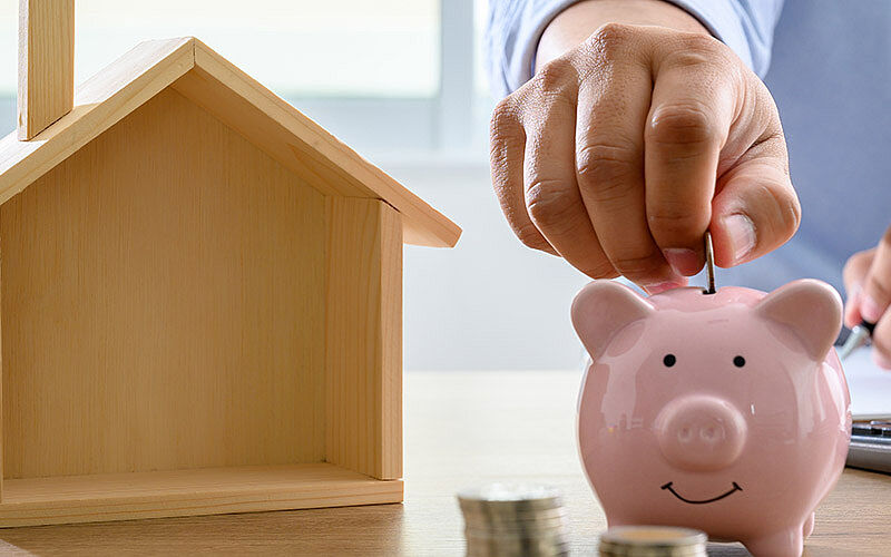 holzhaus und sparschwein mit geld