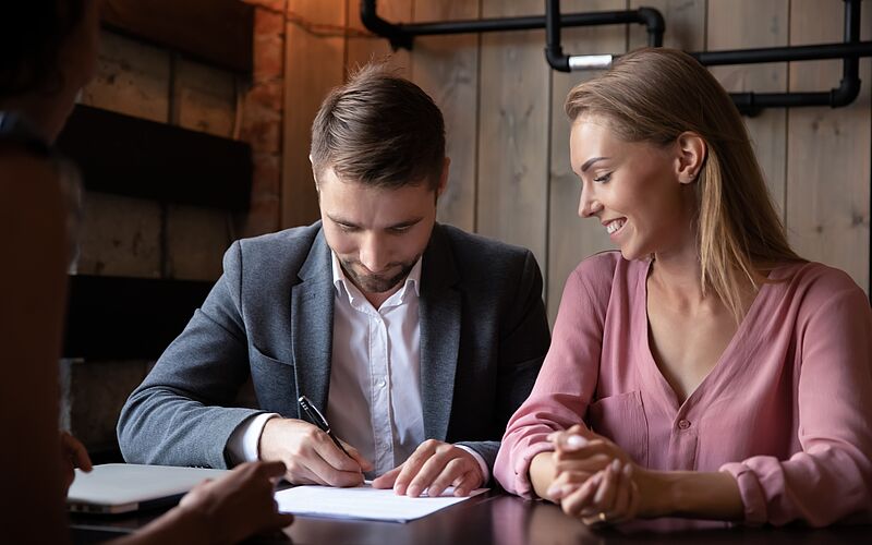 ein paar unterschreibt einen partnerschaftsvertrag