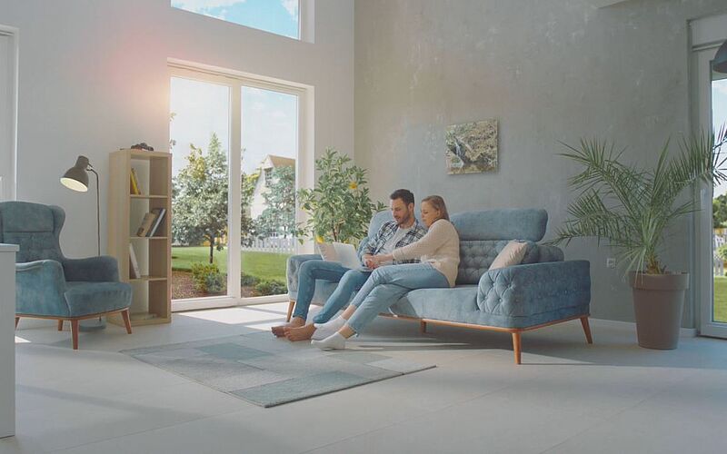 Paar auf Sofa in eigener Wohnung