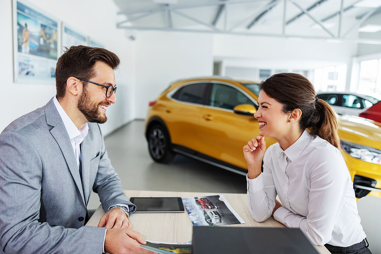 mann berät frau im autohaus