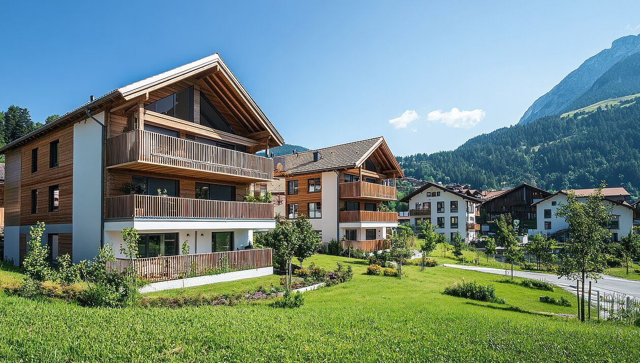 Alpine Luxushäuser vor Bergkulisse