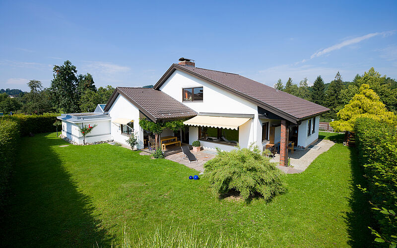 Einfamilienhaus mit Garten in der Sonne.