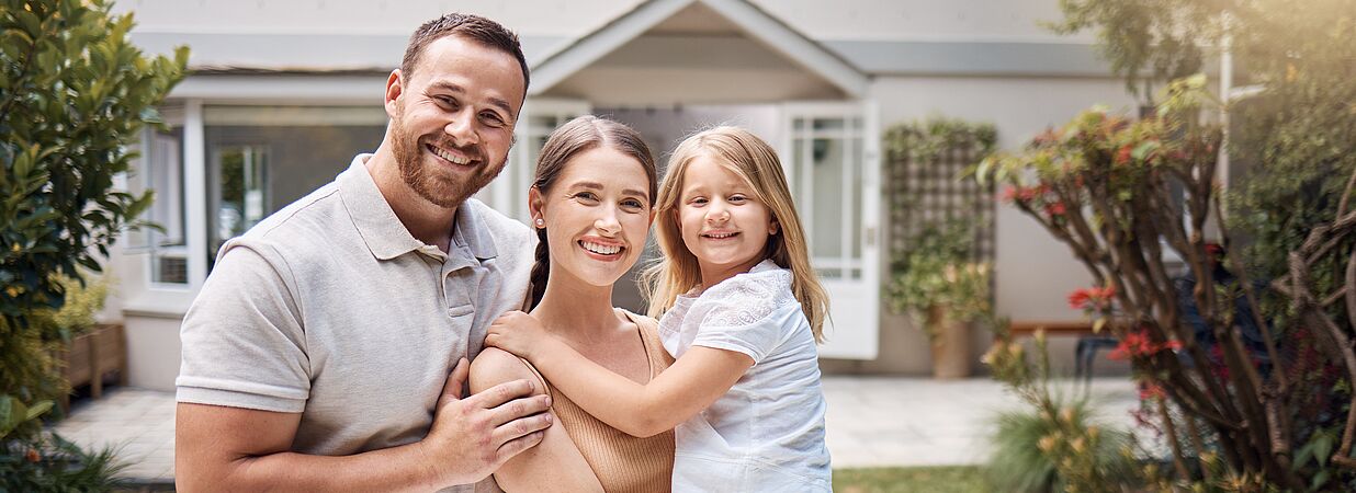 Glückliche Familie vor Hauseingang