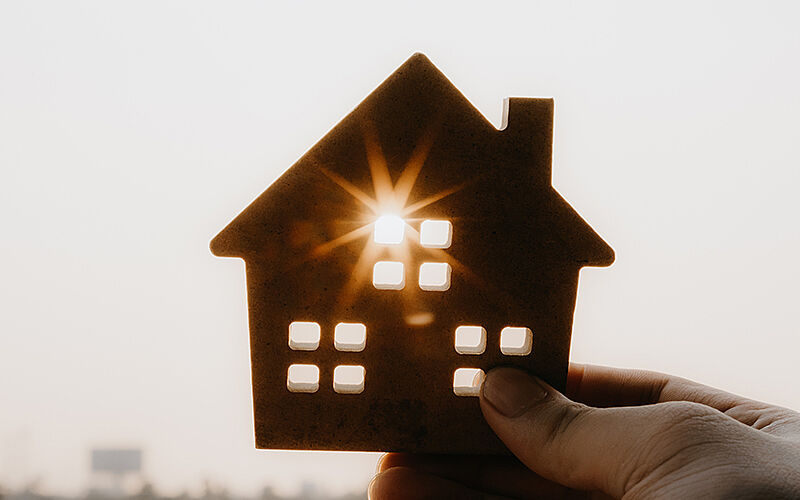 sonnenstrahlen scheinen durch kleines holzhaus