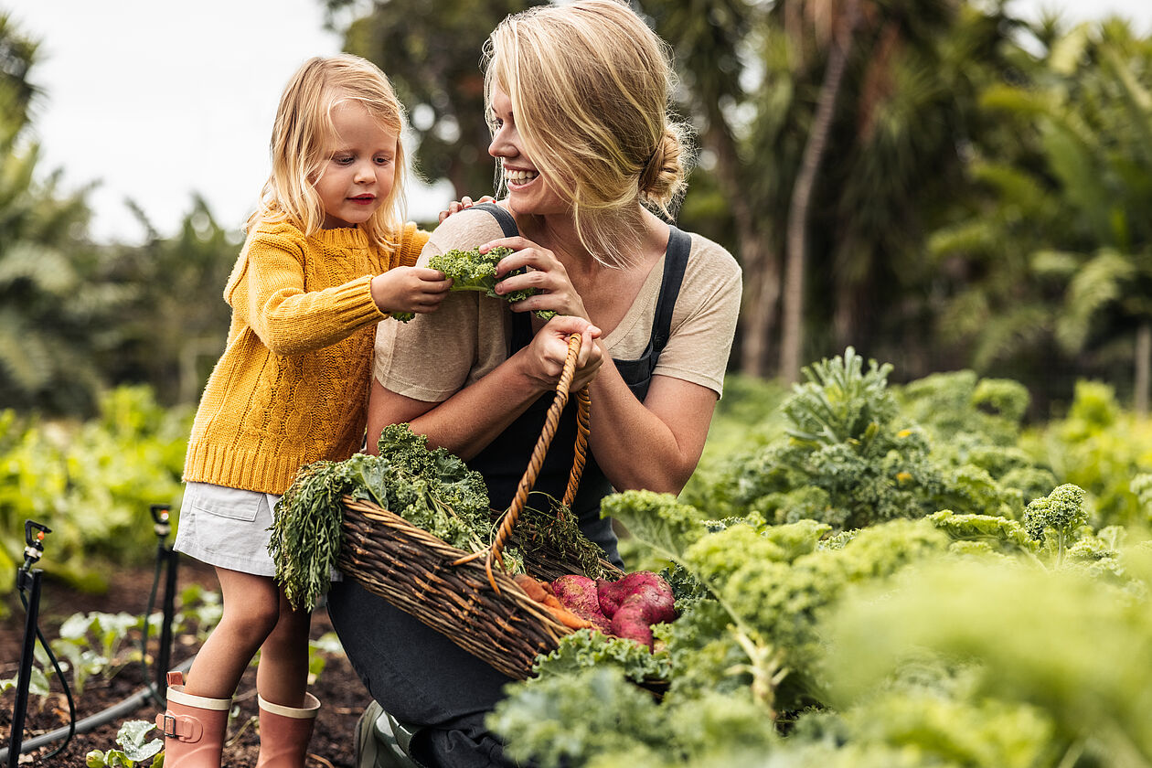 Frau mit Kind beim Gemüse Anbau