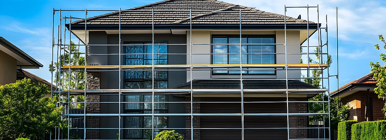 Modernes zweigeschossiges Haus mit Baugerüst während einer Kernsanierung