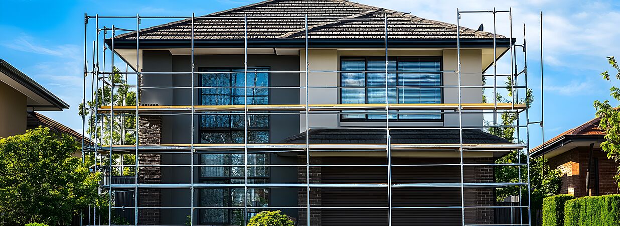 Modernes zweigeschossiges Haus mit Baugerüst während einer Kernsanierung