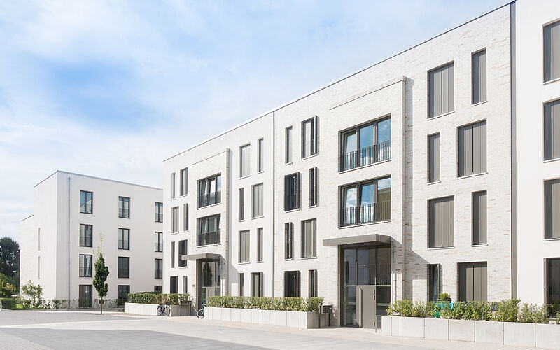 Moderne Wohnanlage in Österreich mit mehreren Eingängen und Balkonen.