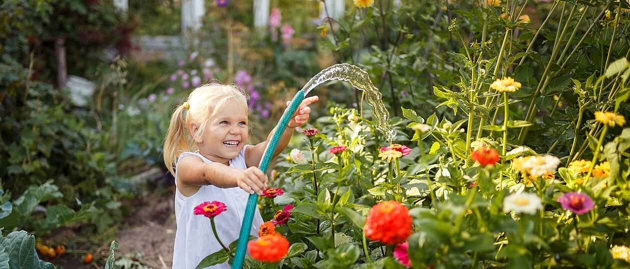 Kind wässert den Garten