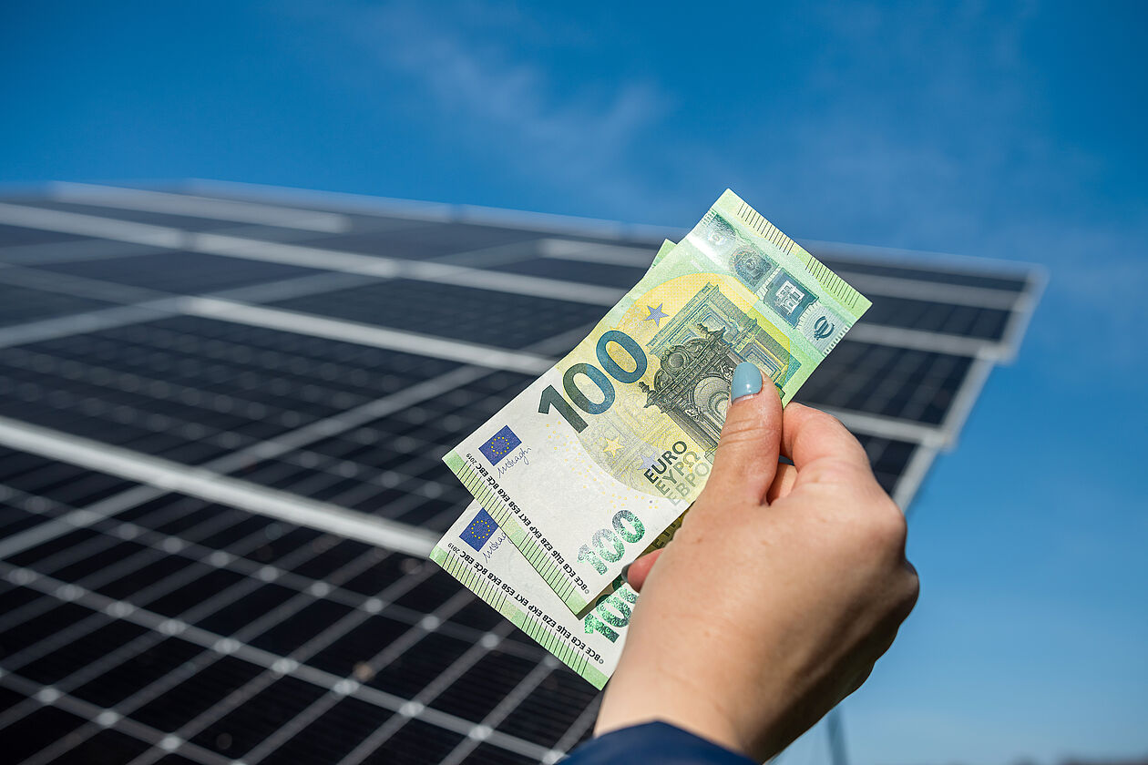 Mann baut Photovoltaik Anlage ein