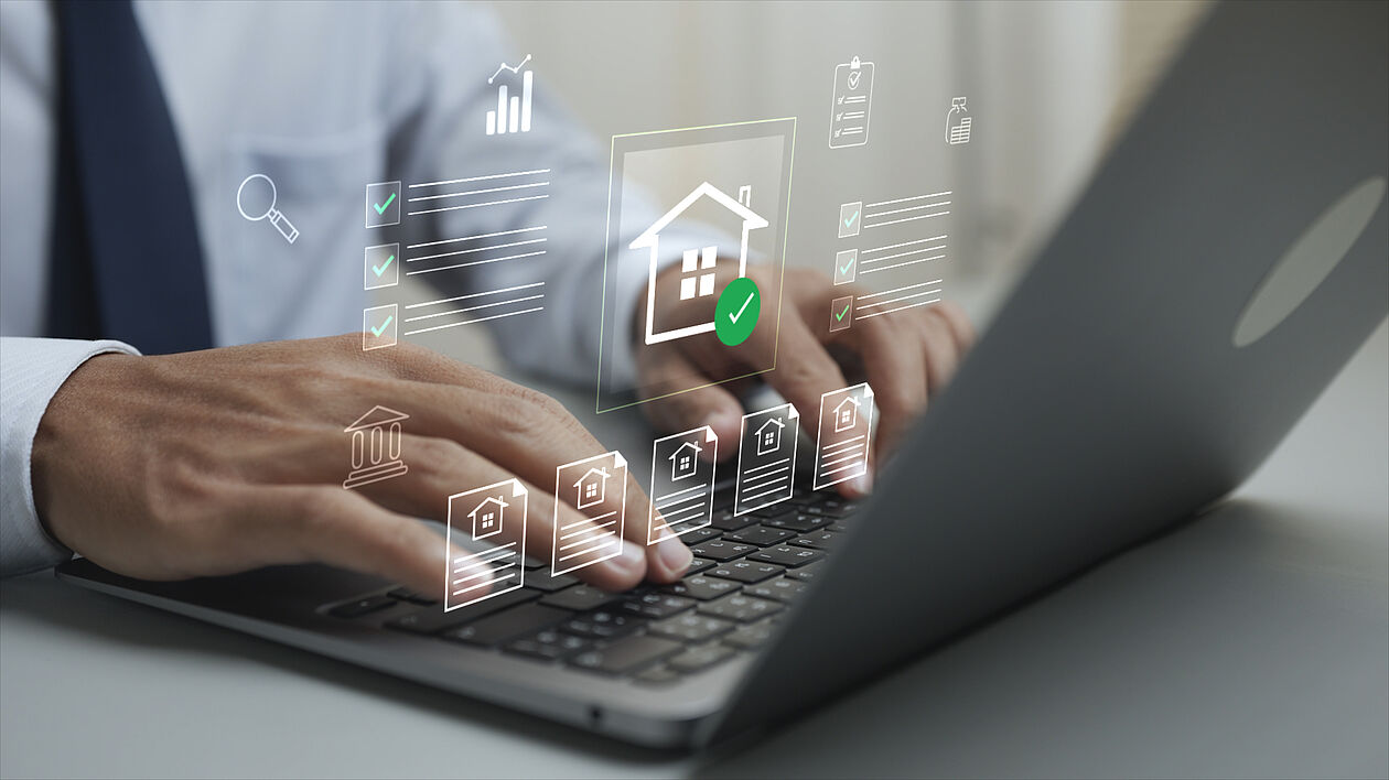 Eine Person prüft digitale Immobilienunterlagen am Laptop.