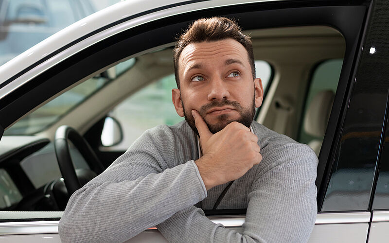 nachdenklicher mann im auto