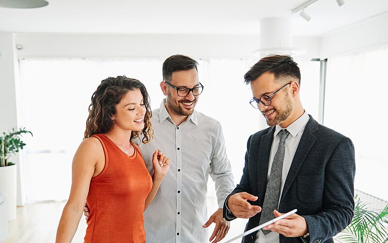 Makler zeigt Paar seine Mappe