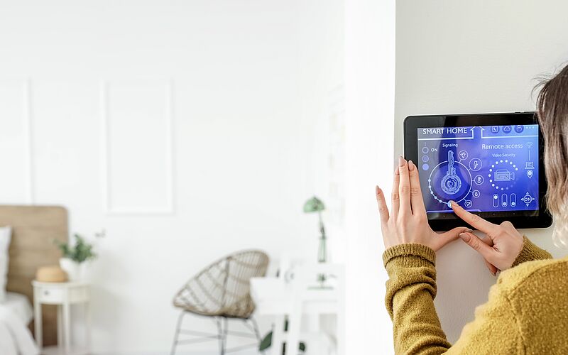 Frau beim Einstellen eines Smart Home Systems