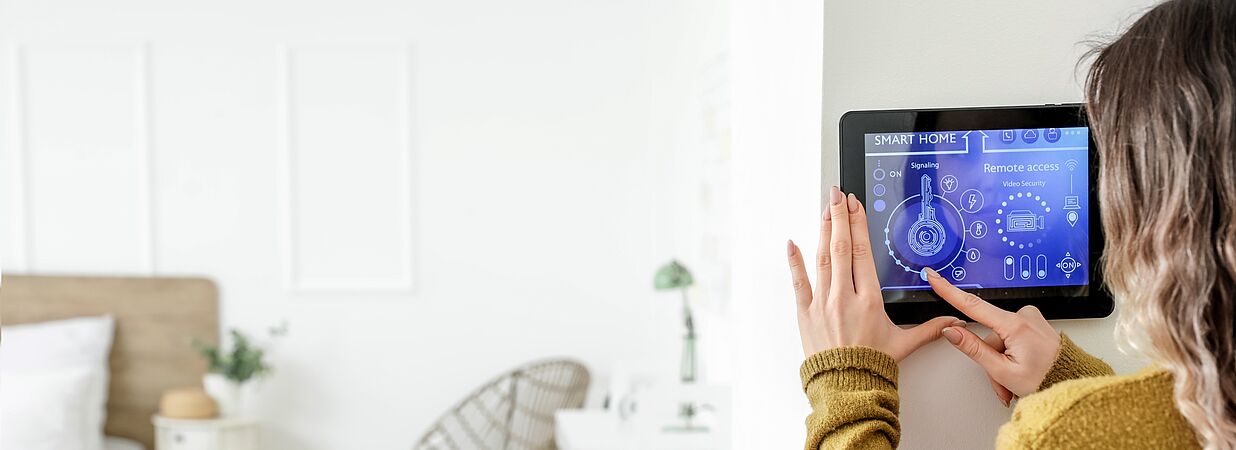 Frau beim Einstellen eines Smart Home Systems