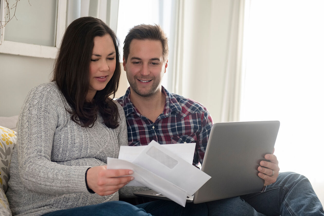 mann und schwangere frau mit laptop