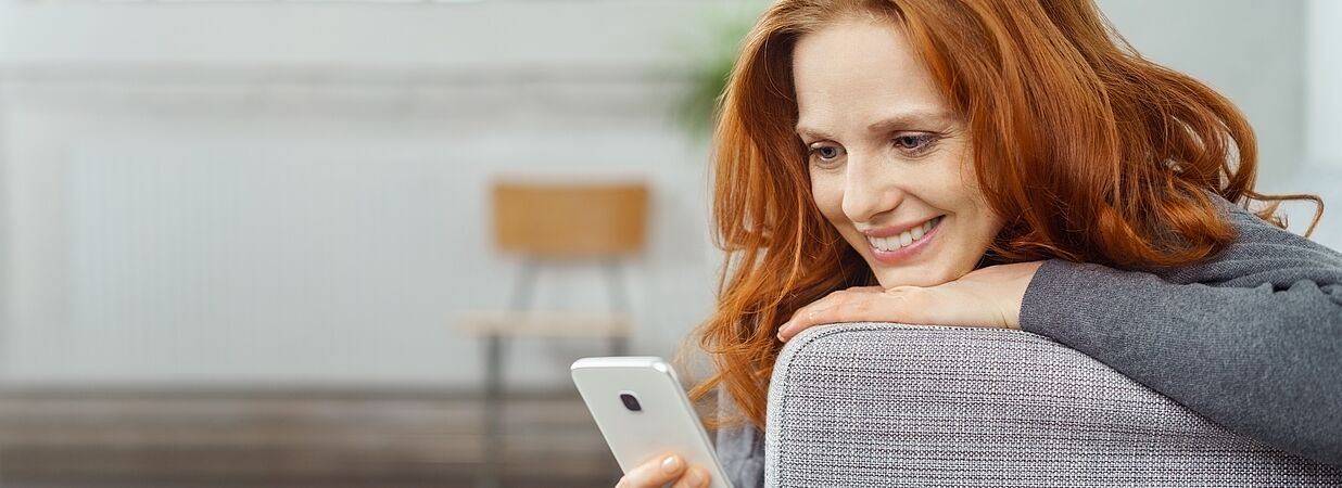 Frau lächelt in Handy