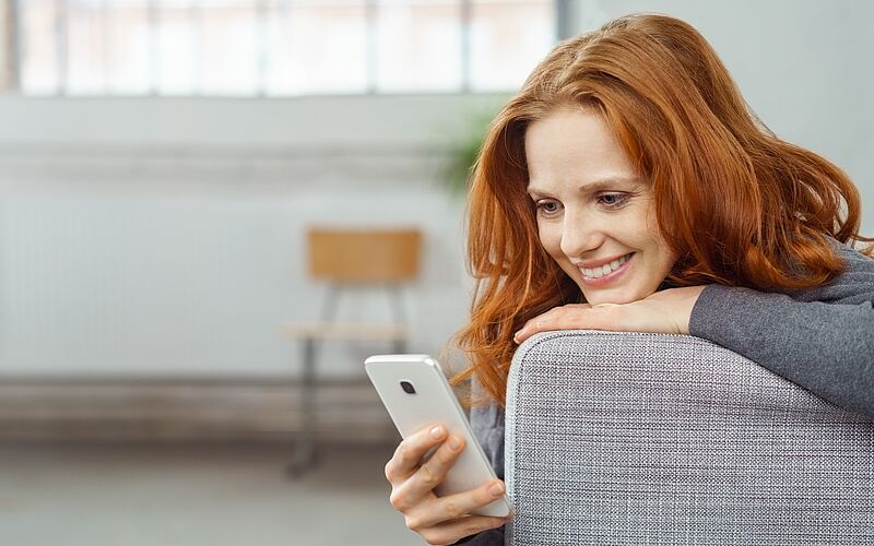 Frau lächelt in Handy