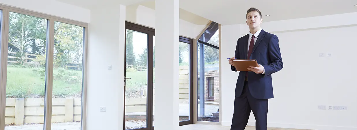 immobilienmakler zeigt wohnung