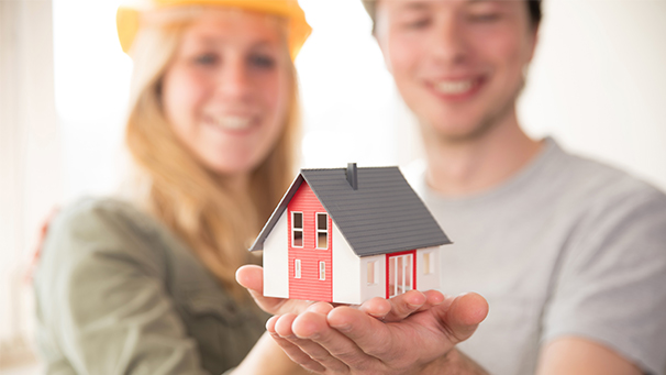 mann und frau mit bauhelm und holzhaus