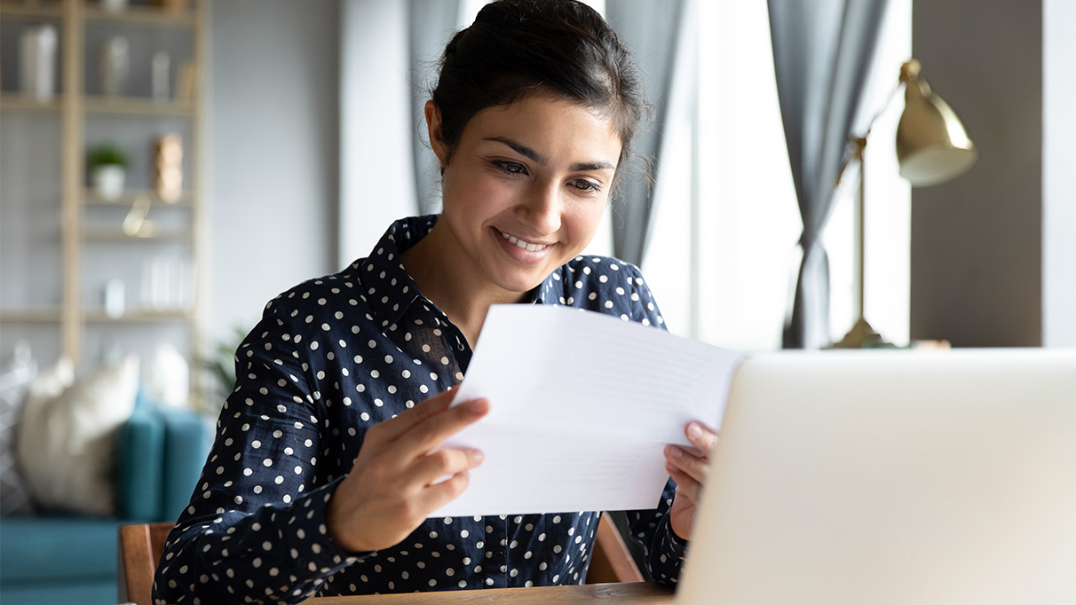 glückliche frau mit einem blatt papier in der hand